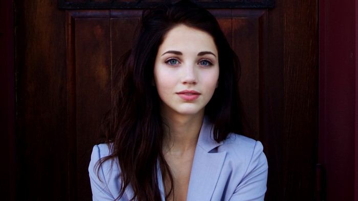 Woman with black hair and blue eyes wearing a blazer