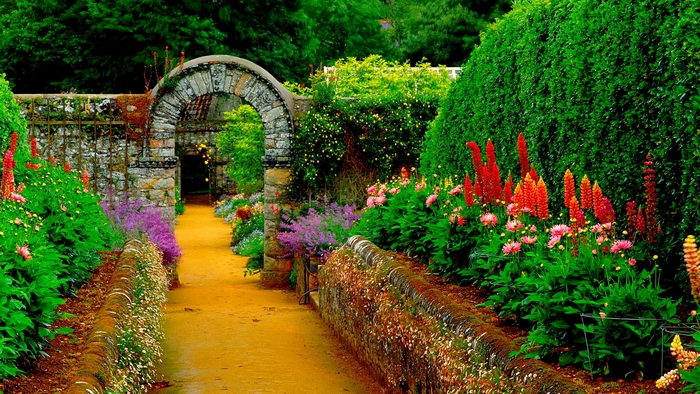 Garden path with stone archway and colorful flowers
