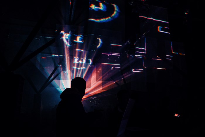 Silhouette of a person in front of colorful strobe lights