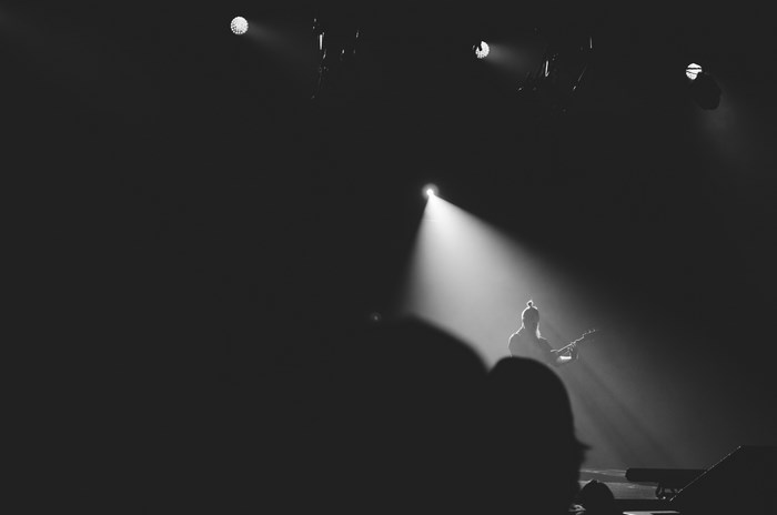 Guitarist performing on stage in spotlight