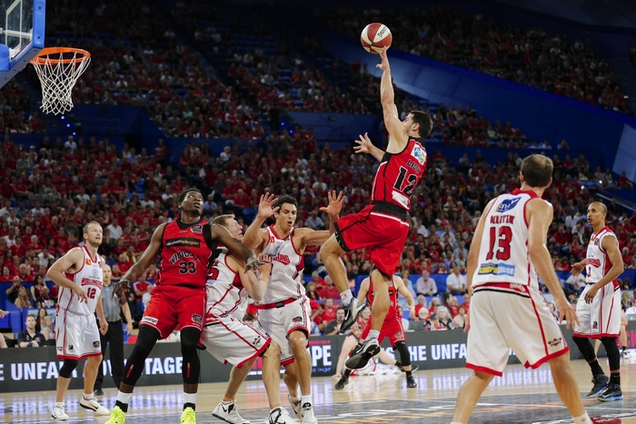 Basketball players in red and white uniforms during a game