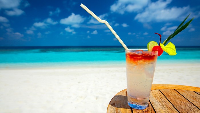 Tropical cocktail on a beach with ocean and sky