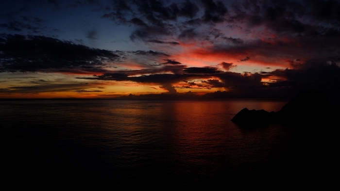 Dark ocean sunset with colorful clouds