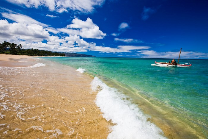 Beach in Hawaii with a person in a boat