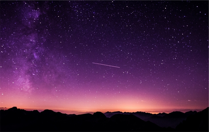 Purple night sky with stars and mountains