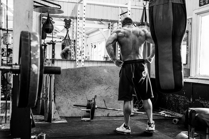 Bodybuilder in a gym with punching bags and weights
