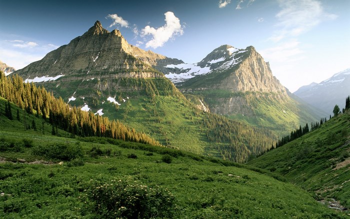 Mountain range with green slopes and snow-capped peaks