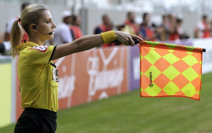 Fernanda Colombo, football referee, holding a flag