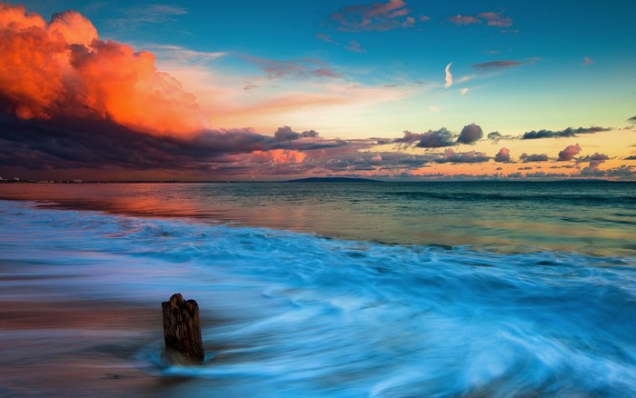 Ocean waves at sunset with dramatic clouds