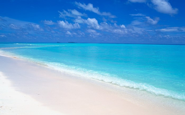 Turquoise ocean waves on a white sand beach