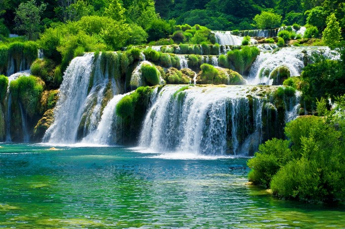 Lush Green Waterfalls Cascading Into Clear Pool