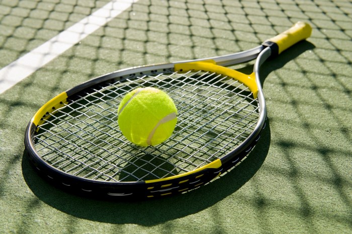 Tennis racket and ball on court