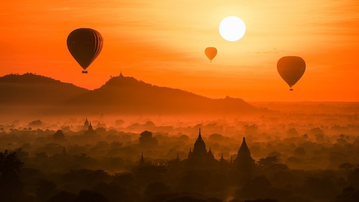 Hot air balloons over ancient temples at sunrise