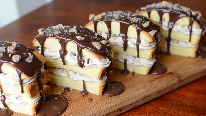 Four chocolate drizzled layered cakes with cream filling