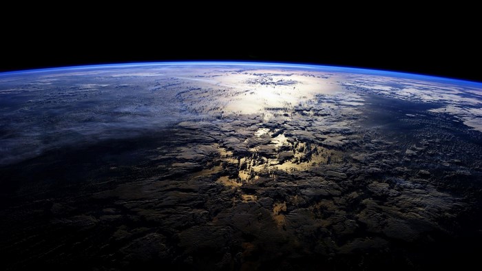 Earth from space with clouds and sunlight