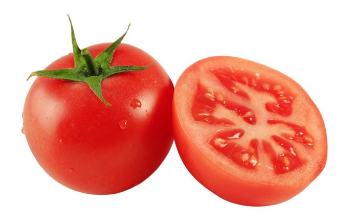 Whole and halved tomato with water droplets