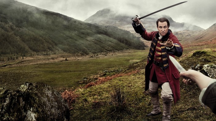 Man in red coat with sword and knife in Scotland