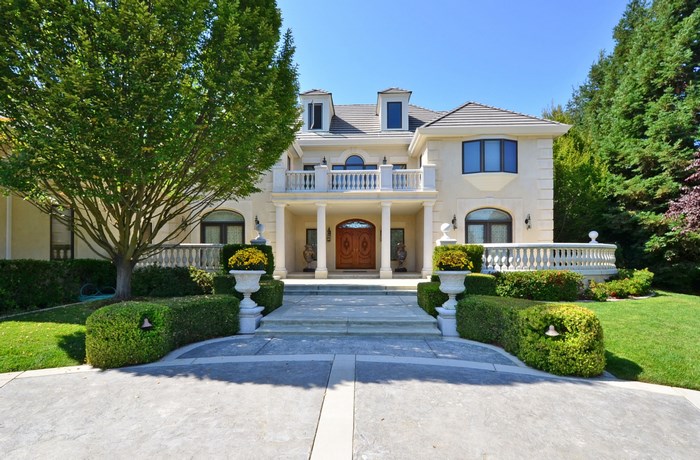 Luxury mansion with manicured gardens and trees