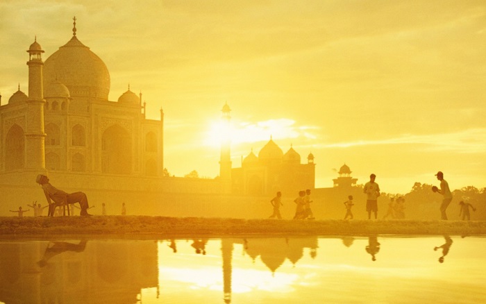 Taj Mahal at sunrise with people playing