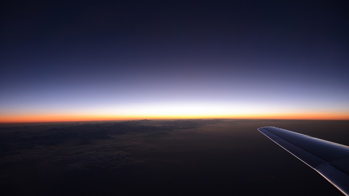 Airplane wing over mountains at sunset 4K