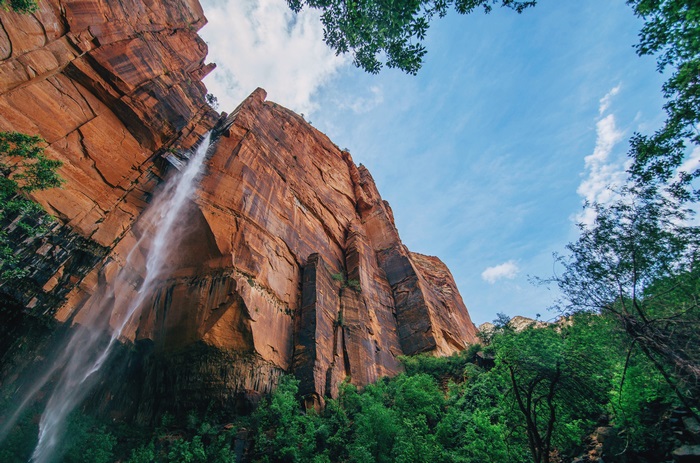 Waterfall cascading down a massive sandstone cliff face