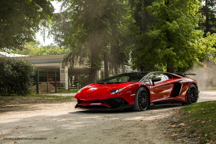 Red Lamborghini Aventador on a dirt road