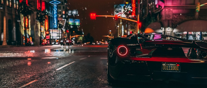 Black sports car on a wet city street at night