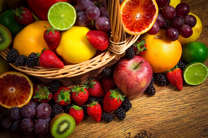 Basket of assorted fruits on a wooden table