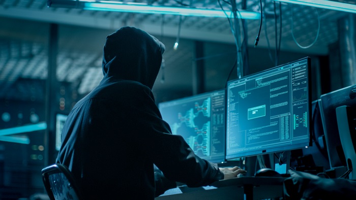 Hacker in Hoodie Working on Computers