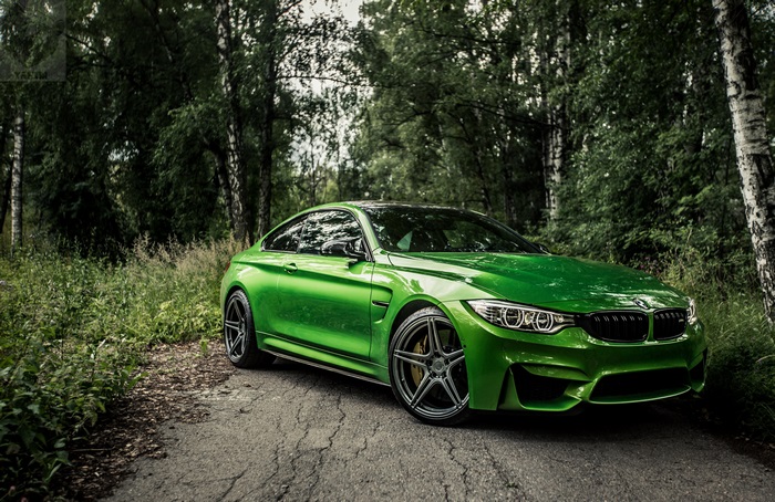 Green BMW M4 Coupe on a forest road