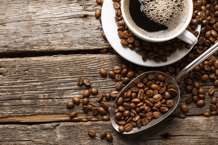 Coffee beans and a cup of coffee on a wooden table