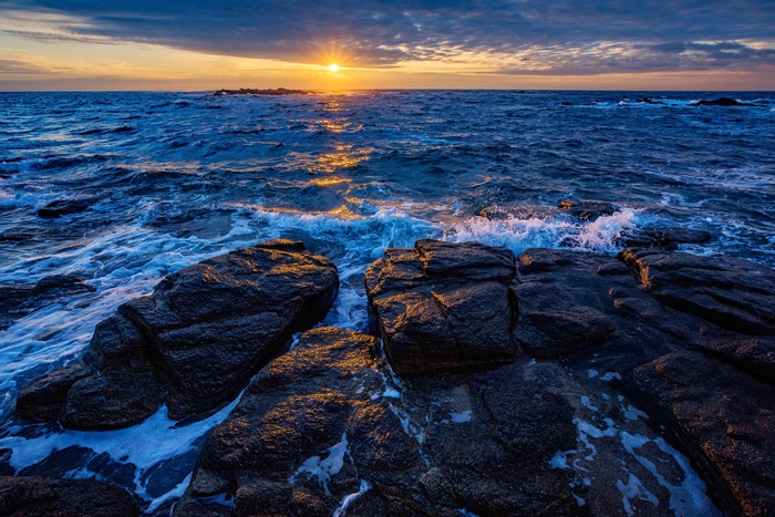Ocean sunset over rocky shore
