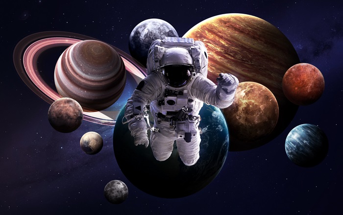 Astronaut floating among planets in space