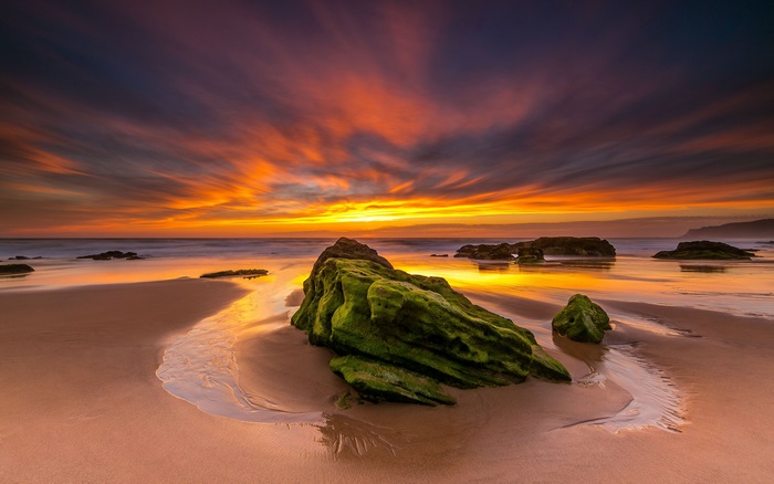Ocean sunset with rocks on beach 4K