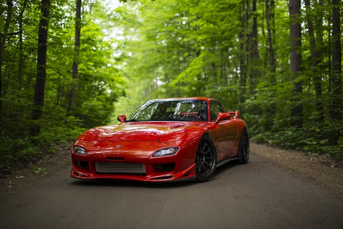 Red Mazda RX-7 on a forest road