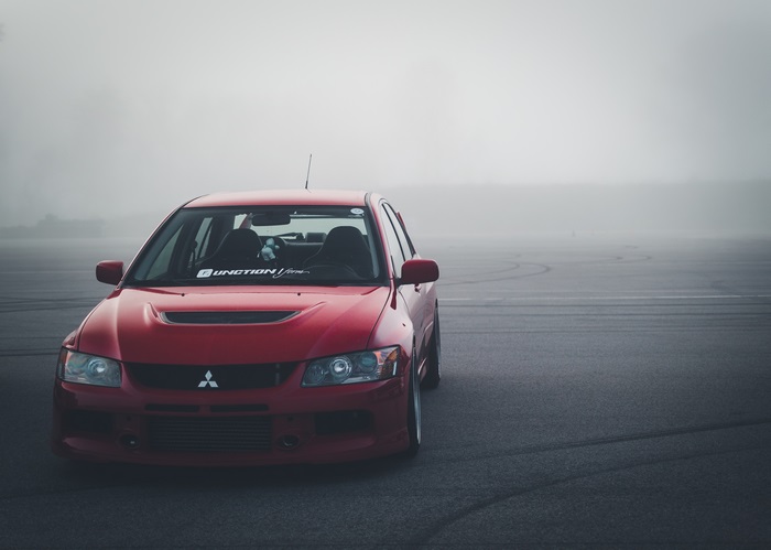 Red Mitsubishi Lancer Evolution VIII in Fog