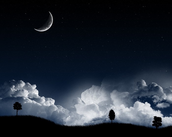 Night sky with crescent moon, stars, and clouds over silhouetted landscape