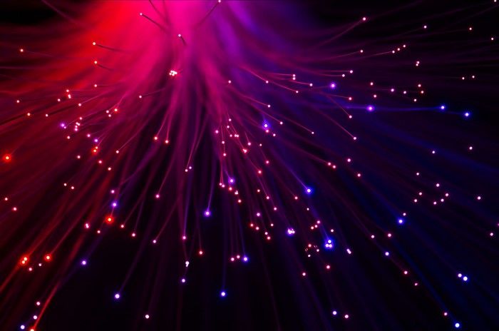 Abstract macro view of red and purple optic fibers with bokeh lights