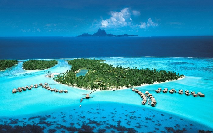 Overwater bungalows in Bora Bora lagoon with distant island