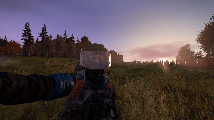 DayZ player wearing riot helmet at sunset