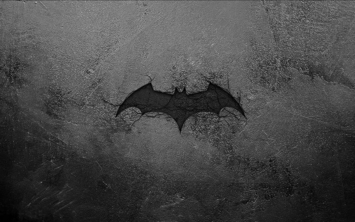 Batman logo cracked on a dark textured surface