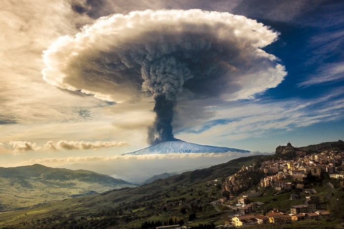 Mount Etna volcano eruption with town in Sicily, Italy