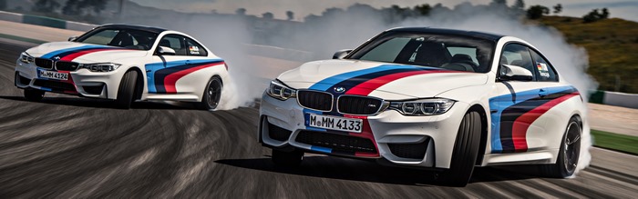 Two BMW M4 cars drifting on a race track