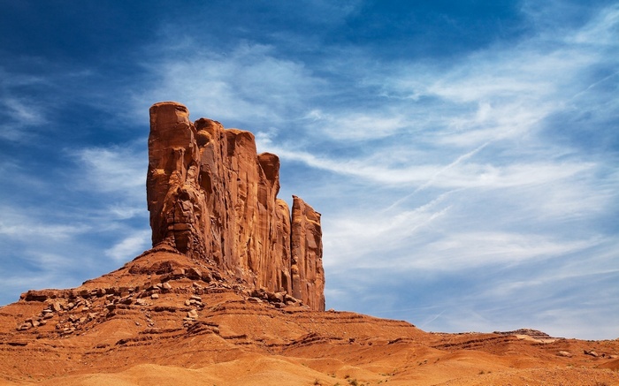 Monument Valley rock formation under a blue sky