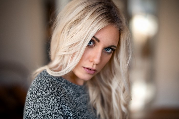 Woman with blonde hair and blue eyes wearing a sweater