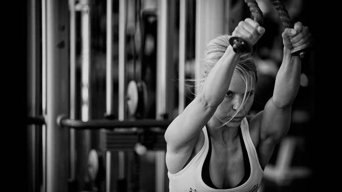 Woman performing cable crossover exercise in gym