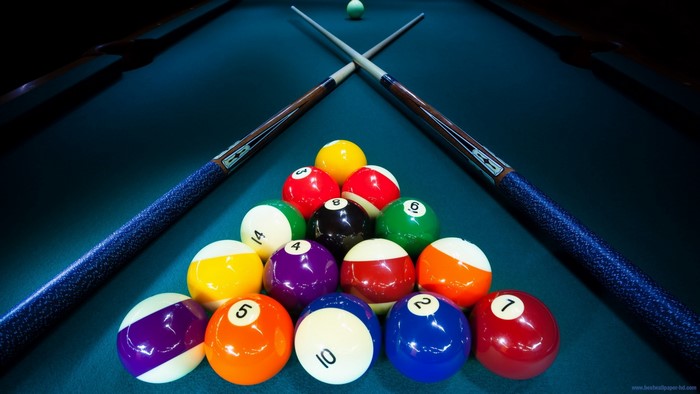 Billiard balls and cues on a pool table