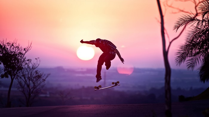 Skateboarder performing a trick at sunset