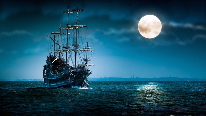 Pirate ship sailing under a full moon