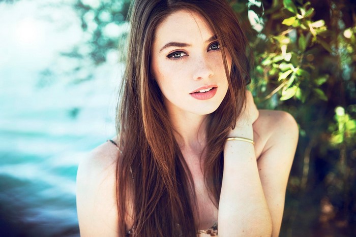 Woman with long brown hair and freckles outdoors